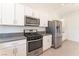 Well-lit kitchen with white cabinets and stainless steel appliances, including a range and refrigerator at 5705 Sovereign Way, Las Vegas, NV 89130
