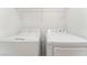Modern laundry room featuring a white, front-loading washer and dryer, with shelving above at 5705 Sovereign Way, Las Vegas, NV 89130