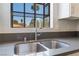 Close-up of a kitchen sink with a modern faucet and a view of palm trees outside the window at 5705 Sovereign Way, Las Vegas, NV 89130