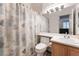 Bathroom with a tub and shower with patterned shower curtain and a wood-finish vanity at 5978 Autumn Harvest Ave, Las Vegas, NV 89142