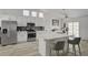 Well-lit kitchen featuring white cabinets, stainless steel appliances, and an island with barstool seating at 6128 Casper Sands Ct, North Las Vegas, NV 89031