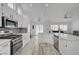 Spacious kitchen boasts a large island with stainless steel appliances and light wood-look floors at 6128 Casper Sands Ct, North Las Vegas, NV 89031