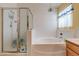Bright bathroom featuring a separate shower and tub with white tile surround at 6222 Eliza Ln, North Las Vegas, NV 89031