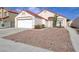 Single-story home featuring desert landscaping, a two-car garage, and a red tile roof at 6222 Eliza Ln, North Las Vegas, NV 89031