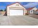 A two-car garage with a white door and a concrete driveway in front of the home at 6222 Eliza Ln, North Las Vegas, NV 89031
