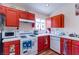 Cozy kitchen featuring red cabinets, white appliances, and tile countertops at 6222 Eliza Ln, North Las Vegas, NV 89031