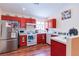 Efficient kitchen featuring modern appliances, red cabinetry, and ample counter space at 6222 Eliza Ln, North Las Vegas, NV 89031