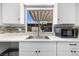 Bright kitchen featuring white cabinets, stainless steel sink, and sleek countertop, offering a modern design at 6442 Ironbark Ln, Las Vegas, NV 89107