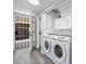 Laundry room featuring stainless steel washer and dryer, storage cabinets and access to front entryway at 6442 Ironbark Ln, Las Vegas, NV 89107