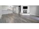 Spacious living room featuring new gray flooring, fireplace with mounted television, and an open bar to the kitchen at 6442 Ironbark Ln, Las Vegas, NV 89107