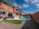 Backyard pool with a spa area, artificial turf, patio area with furniture, and desert landscaping at 7125 Mountain Den Ave, Las Vegas, NV 89179