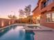 Backyard pool and spa area illuminated at twilight, featuring a private wall and tasteful landscaping at 7125 Mountain Den Ave, Las Vegas, NV 89179