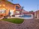 Backyard pool and spa with landscaping, outdoor seating, and exterior lighting, creating a cozy atmosphere at 7125 Mountain Den Ave, Las Vegas, NV 89179