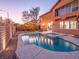 Backyard pool and spa area with exterior lighting, mature landscaping, and a private setting at 7125 Mountain Den Ave, Las Vegas, NV 89179