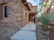 Inviting front entrance with stone details, desert landscaping, and covered entry at 7125 Mountain Den Ave, Las Vegas, NV 89179
