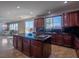 Open-concept kitchen with an island, dark wood cabinets, and stainless steel appliances at 7125 Mountain Den Ave, Las Vegas, NV 89179