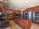 Gourmet kitchen featuring cherry cabinets, a center island, and stainless steel appliances at 7125 Mountain Den Ave, Las Vegas, NV 89179