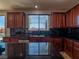Well-lit kitchen area featuring dark granite countertops and cherry-stained wood cabinets at 7125 Mountain Den Ave, Las Vegas, NV 89179