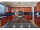 Kitchen with dark granite countertops, cherry cabinets, and stainless steel appliances at 7125 Mountain Den Ave, Las Vegas, NV 89179