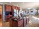 Open concept kitchen with cherry wood cabinets, granite countertops, and stainless steel appliances at 7125 Mountain Den Ave, Las Vegas, NV 89179