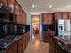 Gourmet kitchen featuring black countertops, stainless steel appliances, and rich wood cabinetry at 7125 Mountain Den Ave, Las Vegas, NV 89179