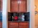 Coffee bar area with dark countertops and matching wooden cabinetry in an elegant setting at 7125 Mountain Den Ave, Las Vegas, NV 89179