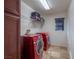Efficient laundry room featuring modern red washer and dryer set, storage shelves, and tiled flooring at 7125 Mountain Den Ave, Las Vegas, NV 89179