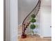 Elegant curved staircase with dark wood railing and iron spindles, complemented by travertine floors and accent lighting at 7125 Mountain Den Ave, Las Vegas, NV 89179