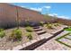 Landscaped backyard with decorative fountain, stone steps and patio area at 715 Drammatico Pl, Henderson, NV 89011