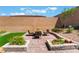 Backyard with a lounge area, fire pit, flower bed, and well-maintained artificial grass at 715 Drammatico Pl, Henderson, NV 89011