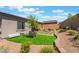 Expansive backyard with lush green grass, mature landscaping, and a cozy seating area for outdoor enjoyment at 715 Drammatico Pl, Henderson, NV 89011