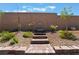 Backyard landscaped with elegant stone steps, fountain, and flourishing shrubs at 715 Drammatico Pl, Henderson, NV 89011