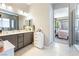 Bathroom featuring dual sinks, vanity, and doorway to bedroom at 715 Drammatico Pl, Henderson, NV 89011