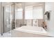 Bathroom with a separate tub, shower, and window with white blinds at 715 Drammatico Pl, Henderson, NV 89011