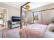 Bedroom features a four poster bed, bright natural light, pink accents, and backyard access at 715 Drammatico Pl, Henderson, NV 89011