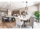 Dining room with gray cabinets, quartz counters, island seating, and an open layout at 715 Drammatico Pl, Henderson, NV 89011