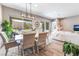 Open dining area with modern lighting, hardwood floors, and easy access to the backyard at 715 Drammatico Pl, Henderson, NV 89011