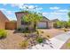 Inviting single-story home with desert landscaping and a brick paver driveway leading to a two-car garage at 715 Drammatico Pl, Henderson, NV 89011