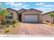 Beautiful one-story home showcasing desert landscaping and a brick paver driveway at 715 Drammatico Pl, Henderson, NV 89011