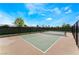 Outdoor tennis court with a green surface and black fencing, ready for a match at 715 Drammatico Pl, Henderson, NV 89011