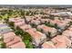 This aerial showcases a neighborhood with beautiful landscaping, lush trees, and warm terracotta roofs at 7450 S Eastern Ave # 2073, Las Vegas, NV 89123