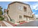 Tan stucco townhome features private garages and access stairs to units above at 7450 S Eastern Ave # 2073, Las Vegas, NV 89123