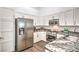 A well-lit kitchen with stainless steel appliances, white cabinetry, and granite countertops at 7450 S Eastern Ave # 2073, Las Vegas, NV 89123
