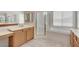Bathroom with shower stall, separate soaking tub, tile floor and wood cabinets at 7504 Via Sistina St, Las Vegas, NV 89131