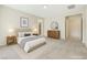 Staged bedroom with tufted headboard, coordinated furnishings, and an ensuite bathroom entrance at 7504 Via Sistina St, Las Vegas, NV 89131