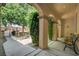 Charming covered patio with arched supports, seating, and a view of the gated front entrance at 7504 Via Sistina St, Las Vegas, NV 89131