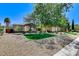 Well-maintained front yard with manicured artificial turf and rock lawn, framed by mature trees at 7504 Via Sistina St, Las Vegas, NV 89131