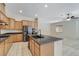 Open-concept kitchen with an island, wood cabinets, granite countertops, and stainless appliances at 7504 Via Sistina St, Las Vegas, NV 89131
