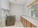 Bright laundry room featuring side-by-side washer and dryer, ample counter space, and a large window at 7504 Via Sistina St, Las Vegas, NV 89131