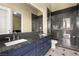 Contemporary bathroom featuring double sinks, a large mirror, and a sleek glass-enclosed shower at 7520 Captains Harbor Dr, Las Vegas, NV 89117